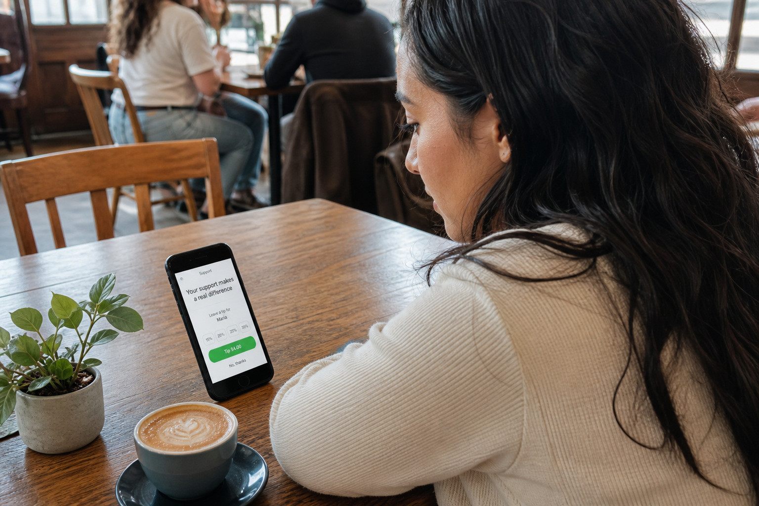 Creator checking a FWDLink page on her phone in a sunlit cafe